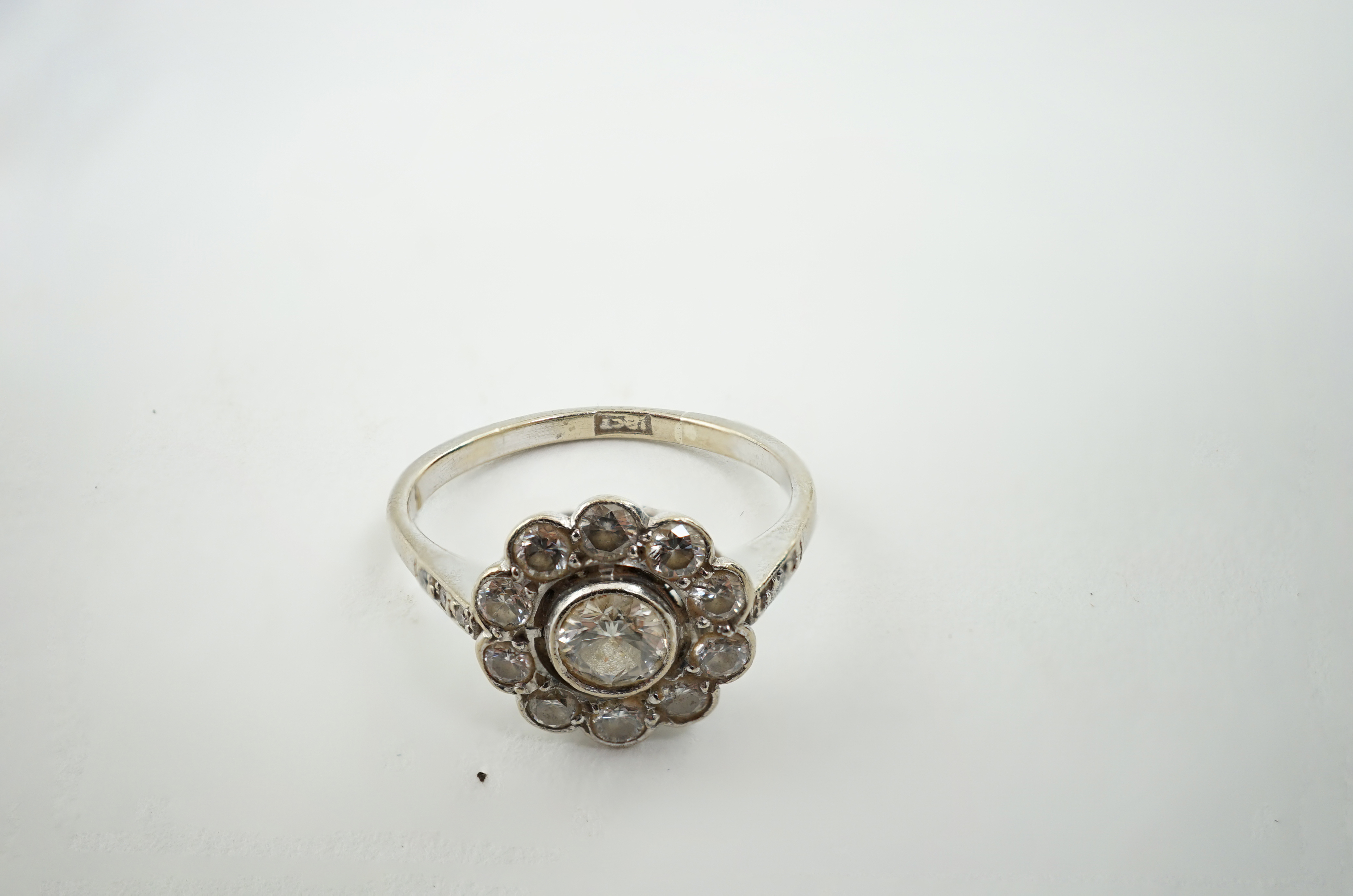 A mid 20th century 18ct white gold and eleven stone diamond set flower head cluster ring